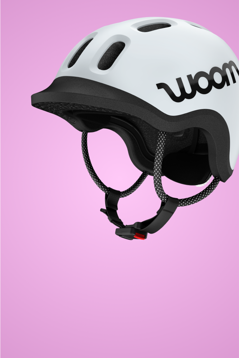 The READY Kids' Helmet in pale grey viewed from the side on a pink background